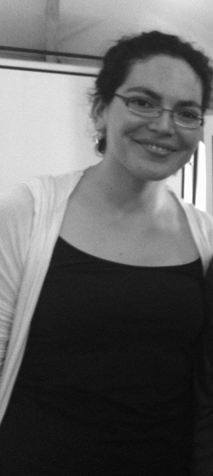 Paulina sonríe de pie en una sala de taller; detrás se ve un lienzo del Ministerio de Salud.